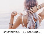 beautiful young boho woman close up with pink feathers and accessories at sunset