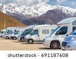 Close up motorhomes parked in a row on background snow mountain nature landscape. 
