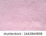 Fluffy pink synthetic fabric background. Soft plush pastel textile texture of winter clothing, baby toys, and home textiles. Rose delicate towel terry cloth. Plush fabric cozy plaid