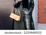 Small photo of Milan, Italy - February, 23, 2022: woman wears yellow Valentino Garavani medium loco bag, street style details