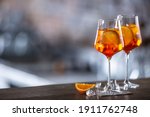 Typical summer sekt drink aperol spritz served in wine glass with aperol, prosecco, soda and a slice of orange.