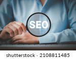 SEO Search Engine Optimization, Woman holding through magnifying glass with text SEO, concept for promoting ranking traffic on website, optimizing your website to rank in search engines.