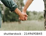 happy senior couple holding hands. hands of man and woman hold each other. romance and love and support in elderly family. faceless husband and wife travel together in nature. people countryside life