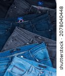 Small photo of Baku. Azerbaijan 11.11.2021 Jeans trousers stack on a white background concept jeans in supermarket and shop. Detailed texture fabric denim background, Blue jeans.