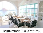 Restaurant table and chairs settings in dinning area with sea view from window