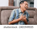 Small photo of Asian senior man presses hand to chest has heart attack suffers from unbearable pain.