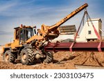 Small photo of Heavy front loader for transportation of bulky goods. Moving bulky goods on the construction site. Heavy construction equipment for transporting materials