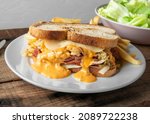 Small photo of Very juicy delicious Reuben sandwich served with french fries and green salad
