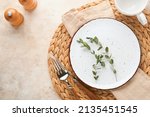 Vintage zero waste silverware. Rustic vintage set of white plate, wooden spoon and fork on napkin for dishes from water hyacinth on light gray concrete background. Empty dishes. Top view. Mock up.