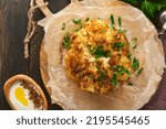 Small photo of Baked cauliflower. Oven or whole baked cauliflower spices and herbs server on wooden rustic board on old wooden vintage table background. Delicious cauliflower. Eyal Shani dish. Perfect tasty snack.