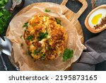 Small photo of Baked cauliflower. Oven or whole baked cauliflower spices and herbs server on wooden rustic board on old gray background table. Delicious cauliflower. Eyal Shani dish. Perfect tasty snack.