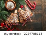 Christmas tree shape puff pastry cakes with chocolate filling, sugar powder and lollipops on old wooden background. Christmas, New Year Appetizer. Festive idea for Christmas or New Year dinner.