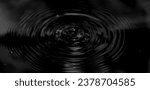 Small photo of Ripple of water or water drop splash on black background. Abstract shape out of the water. Oil ripples from a drop of water in the dark. Rippled liquid with mood effect in black and white.