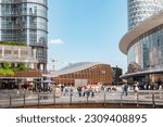 Small photo of Milan, people in modern Gae Aulenti square, summer. Beautiful modern buildings in Porta Nuova district. Tourists in Milan. Milan, Italy Milan, Italy - 27th May 2023