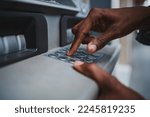 Small photo of Close up shot of a man typing his PIN code on a keyboard of a ATM to withdrawal money from bank