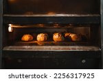 Several artisan breads being baked in a industrial oven