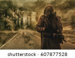 Post-apocalyptic air pollution. Survivor in tatters and gas mask on the background of pipes on abandoned road. Nature protection concept