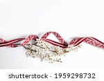Latvian national celebration decoration with a flourishing branch made of Latvian flag ribbon and Lielvarde belt ribbon for independence day of Latvia