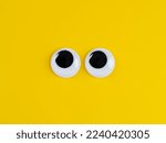 Cute googly eyes funny Isolated on bright yellow background copy space logo