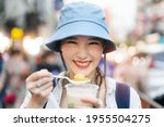 Small photo of Closeup happy young adult asian foodie woman backpack traveller eating asia dessert. People traveling with lifestyle outdoor at China town street food market. Bangkok, Thailand