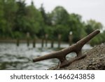 Small photo of Rusting boat tie off with forrest background