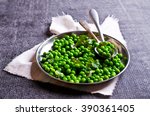 Green peas with mint in a bowl on a dark background. Selective focus.
