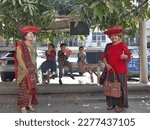 Small photo of Surabaya, East Java, Indonesia - March, 2023 : two mothers wearing Karo Batak clothing with their children wearing traditional Javanese clothing between them