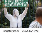 Small photo of Albi, France - October 2, 2021 - "Will you react at the 8th dose ?" : an opponent to the health pass, disguised with a masquerade mask and white blouse, brandishes a placard at a demonstration