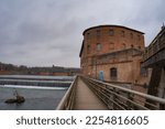 Small photo of A traditional brick water mill at Bazacle low head dam towers a wooden gangplank, which overhangs the River Garonne, in the historic city centre of Toulouse, in the South of France