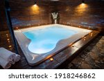 Private whirlpool in a wellness center. Indoor whirlpool with bubbles. Candles around a whirlpool with blue water. 