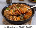 Small photo of Roasted sweet potato parmesan gratin in a cast iron skillet. Close-up, selective focus.