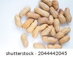 Peanuts (Monkey nuts), unpeeled, in their hard shells. Nuts flat lay composition on a white background.