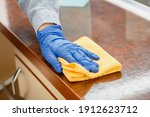 Small photo of Woman wiping table countertop in kitchen by wet cloth rag. Female charwoman hand cleaning disinfect office home restaurant surfaces