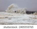 Small photo of Huge Waves battering a sea defence wall during a storm at Hartlepool Headland, County Durham, England, UK.