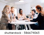 Business people board meeting in modern office while sitting at round table