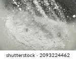 Small photo of Close-up of the mixture in a bucket of powder putty for wall finishing, putty or glaze. Building materials concept. Dry plaster powder topcoat. Selective focus