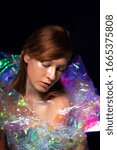 Small photo of Artistic portrait of a beautiful girl with silver make-up. With a luminous dress from a color film