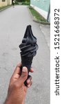 Small photo of czech republic.August 4,2019.A hand holding a co.pletely black ice cream on the street.