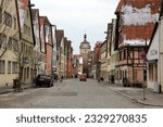 Small photo of Rothenburg ob der Tauber, Germany - February 6, 2023: Galgengasse, Gallows Alley, medieval street in the old town, view toward White Tower, on the winter afternoon