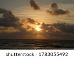 Paradise. Seascape. The sea and ocean waves at sunrise. Beautiful daybreak orange, yellow and red colors in the water, sky and clouds. 