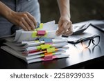 Small photo of Businesswoman hands working in Stacks of paper files for searching and checking unfinished document achieves on folders papers