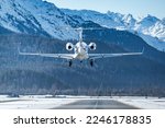 Business jet landing at the alpine airport in Samedan in the engadin valley in the Swiss alps. The luxurious way to travel to the world famous winter ski resort. The way rich people travel. 