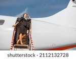 Joyful flight attendant standing in doorway of airplane