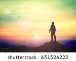 International migrants day concept: Silhouette of humble business man standing on mountain autumn sunset background