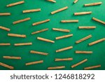 Small photo of Ceylon cinnamon tree sticks scattered on green background, top view