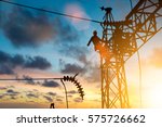 Silhouette electrician work installation of high voltage in high voltage stations safely and systematically over blurred natural background.