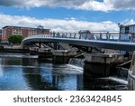Small photo of Belfast County Antrim Northern Ireland June 03 2017 - People walking over the curved Lagan Weir foot bridge across the Lagan Weir in Belfast