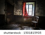 Small photo of Abandoned house, red curtains unhooked