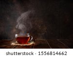 Cup of hot tea with a steam on dark rustic background. Copy space