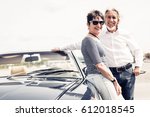 Senior Couple Standing Next To Convertible Classic Car